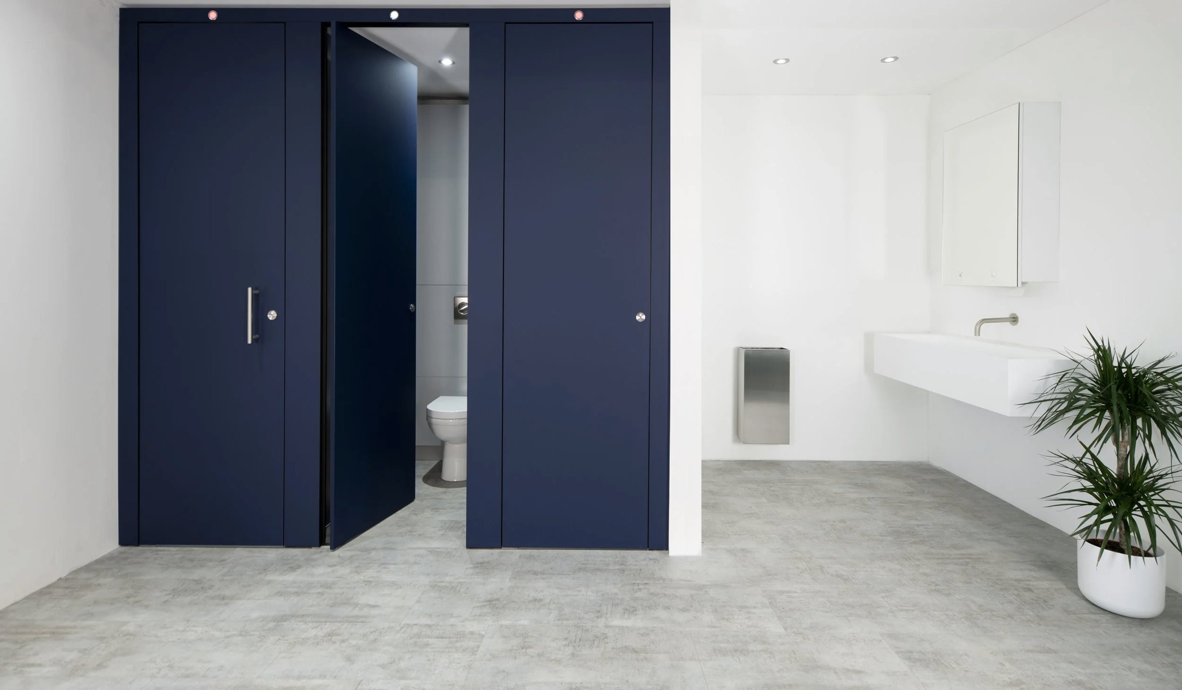 Navy cubicle doors and lockers in a white changing room